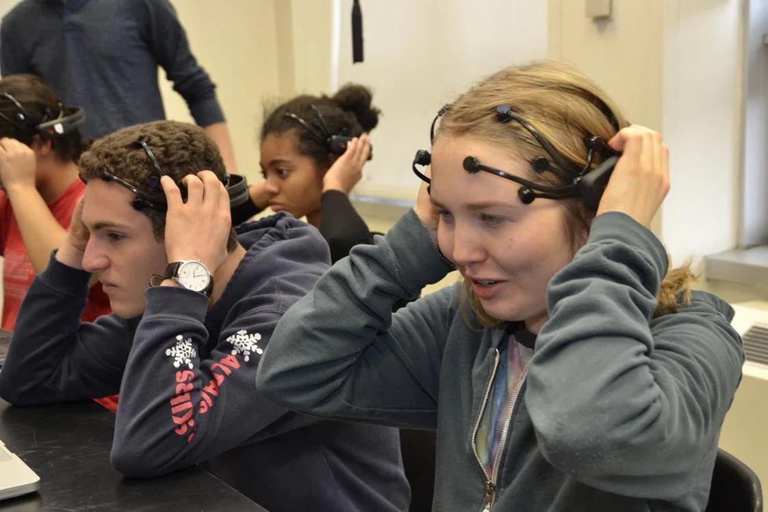 Students fitting Emotiv EEG headsets in a classroom research session