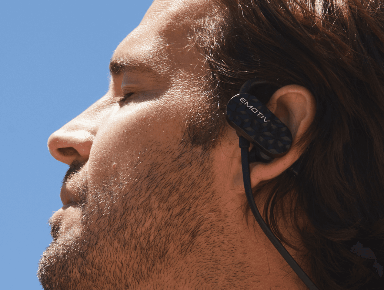 Close up of a man outdoors wearing Emotiv MN8 EEG earbuds
